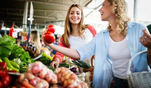Young happy women shopping vegetables and fruits on the market