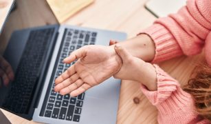 Young beautiful hispanic woman ecommerce business worker suffering for wrist pain at office